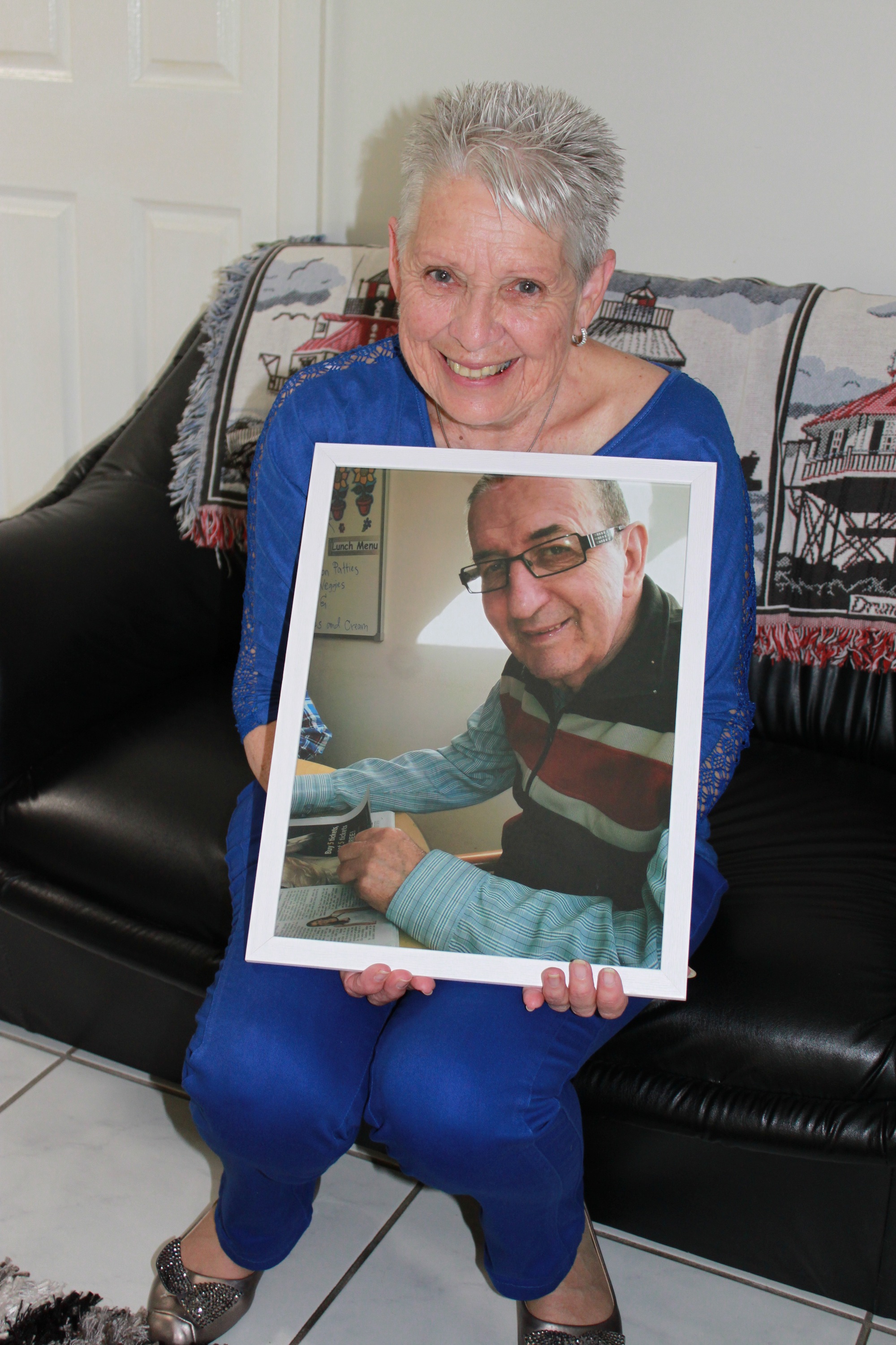 Wendy Smith, holding a picture of her husband George